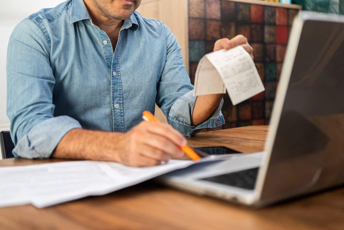 male entering receipts into an online system