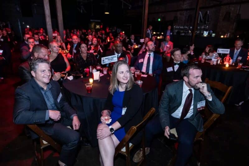 Lane Newsom, InfoWorks President with Aaron Wells sitting at a table at the Titan 100 award ceremony